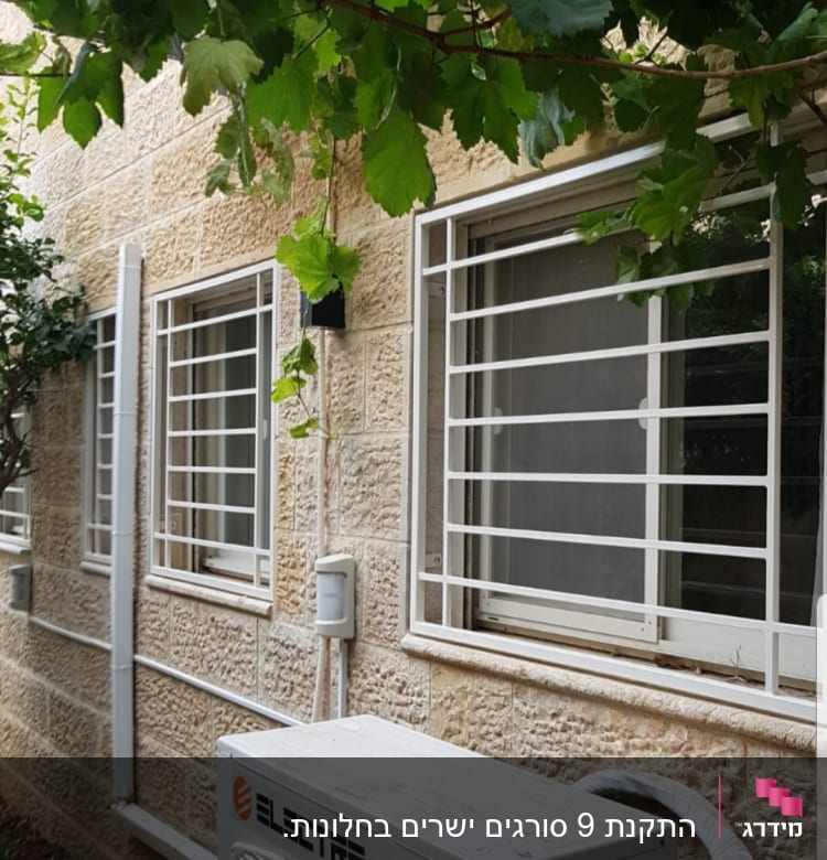 חלונות עם סורגים לבנים על קיר אבן